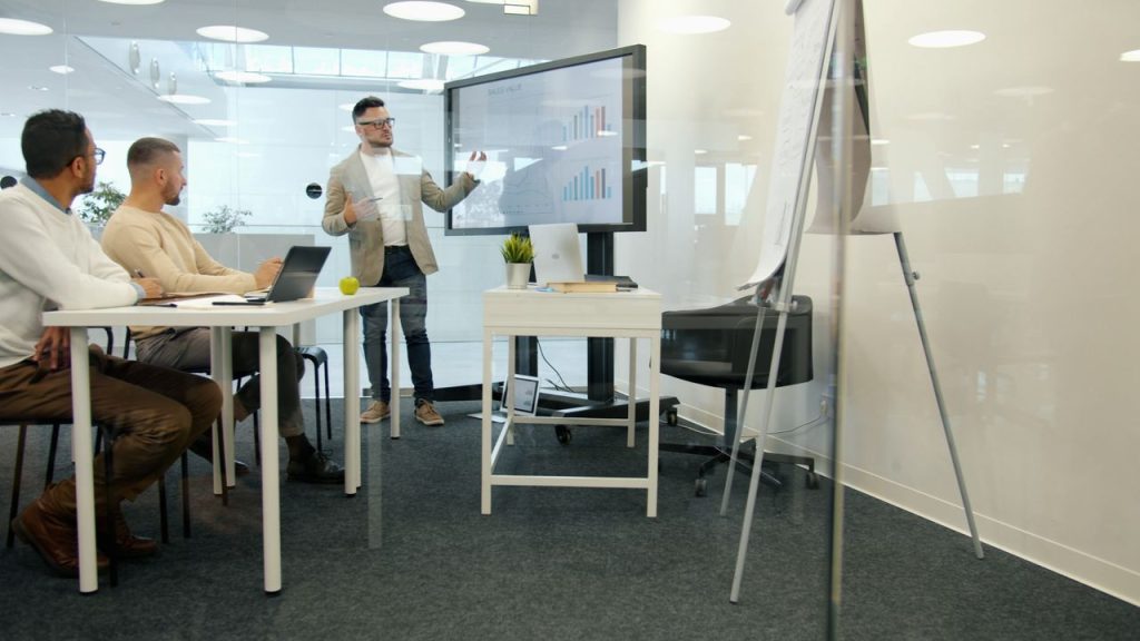 Professional business meeting with presentation of data analytics in modern office setting.